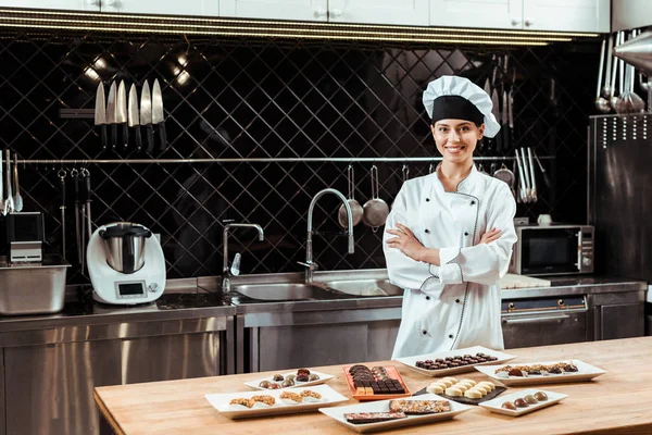 Chocolatier Alegre Chapéu Chef Com Braços Cruzados Perto Doces Chocolate — Fotografia de Stock