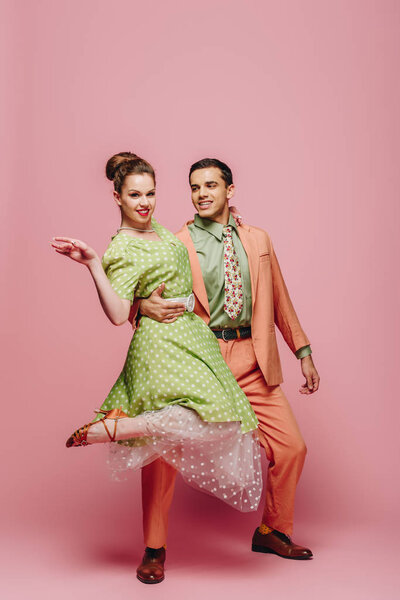 красивая танцовщица обнимает девушку, танцуя буги-вуги на розовом фоне
