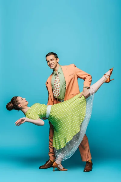 Knap Danser Ondersteuning Meisje Terwijl Dansen Boogie Woogie Blauwe Achtergrond — Stockfoto