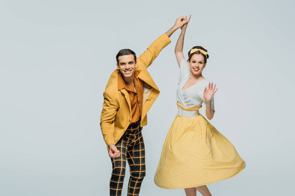 счастливые танцоры держатся за руки, танцуя буги-вуги на сером фоне
