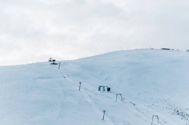 Gondol kaldırma ve beyaz kabarık bulutlu karlı dağ manzarası