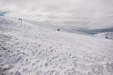 Gondol kaldırma ve beyaz kabarık bulutlu karlı dağların manzarası