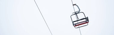 seat of gondola lift against pure white sky background, panoramic shot clipart