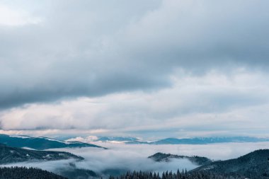 Beyaz kabarık bulutlu karlı dağların manzarası