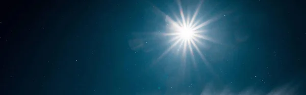 scenic view of bright sun shining in pure dark blue sky, panoramic shot