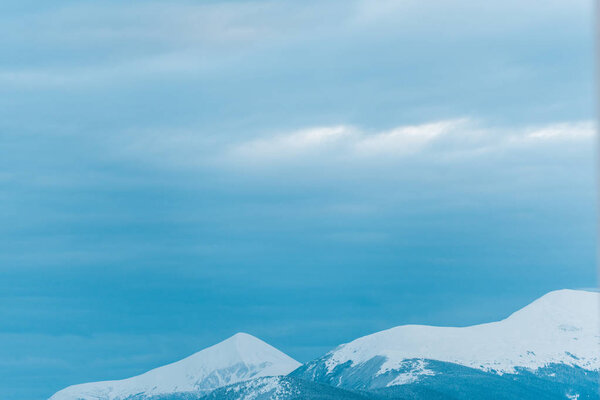 scenic view of snowy mountains with white cloudy sky