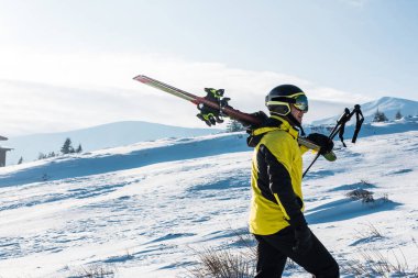 Dağlarda sopayla yürüyen kayakçının yan görüntüsü 