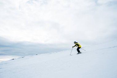 Kışın kask giyen sporcu kayak yapıyor. 