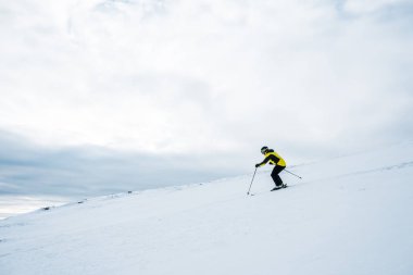 sportsman in helmet skiing in wintertime  clipart