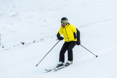 Sopa tutan kayakçı ve kar ile yamaçta kayak yapan 