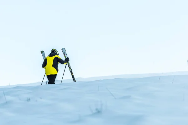 Sciatore Casco Reggendo Bastoni Mentre Cammina Sulla Neve Bianca — Foto Stock