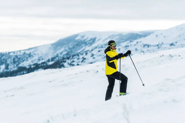 Kasklı Kayakçı Sopa Tutuyor Kışın Yamaçta Duruyor — Stok fotoğraf