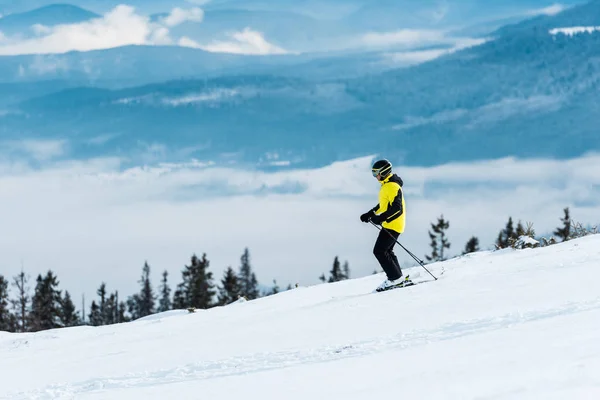 Лыжник Шлеме Держащий Палки Катающийся Лыжах Склоне Зимой — стоковое фото