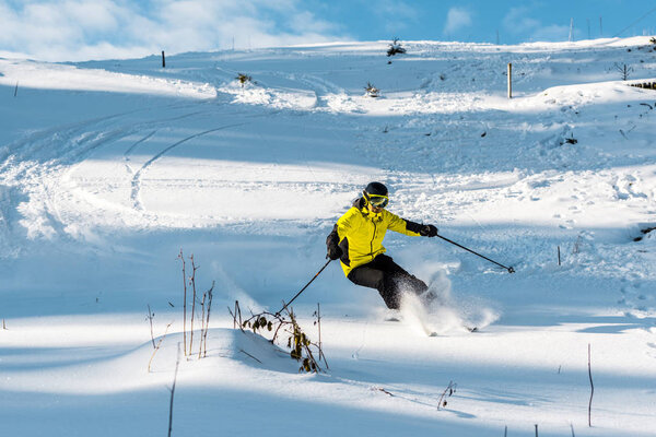 skier in helmet holding ski sticks while skiing on slope outside 