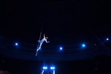 handsome acrobat performing in arena of circus  clipart