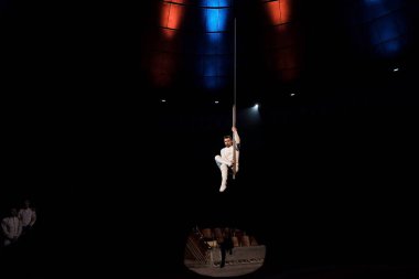 Sirkin metal kutbunda akrobatik hareketler yapan akrobat üzerindeki spot ışıkları 
