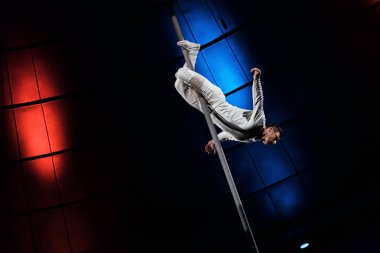 strong acrobat posing while performing in circus  clipart