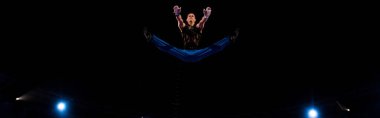 panoramic shot of gymnast jumping while performing in circus   clipart