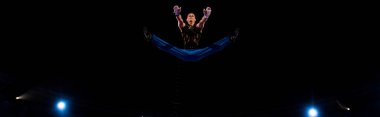 panoramic shot of gymnast jumping while performing in circus   clipart