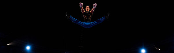 panoramic shot of gymnast jumping while performing in circus  