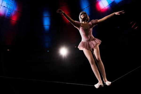 low angle view of attractive aerial acrobat standing on rope