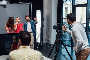 Model ve sanat yönetmeninin yanındaki makyaj sanatçısının seçici odağı 