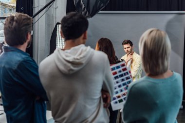 selective focus of handsome model posing in photo studio  clipart