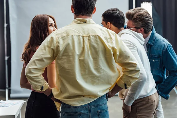 Achteraanzicht Van Man Met Handen Heupen Buurt Van Collega Fotostudio — Stockfoto