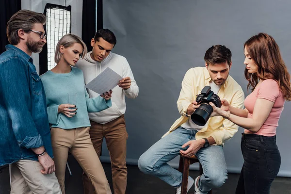 Φωτογράφος Κρατώντας Ψηφιακή Φωτογραφική Μηχανή Κοντά Όμορφο Μοντέλο Και Συνεργάτες — Φωτογραφία Αρχείου