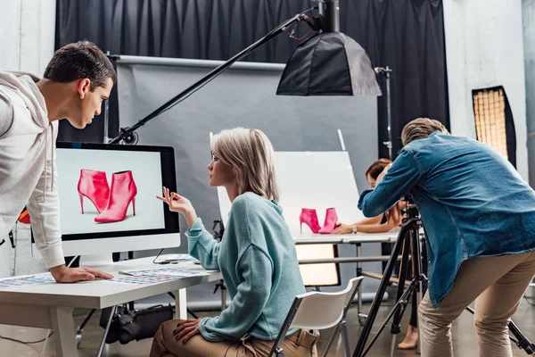 Atractivo Director Arte Gesticulando Cerca Monitor Ordenador Con Foto Zapatos — Foto de Stock