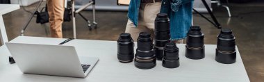 masadaki dizüstü bilgisayarın yanında panoramik fotoğraf lensleri 