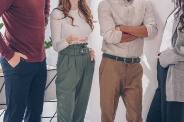 cropped view of coworkers posing while standing in office  clipart