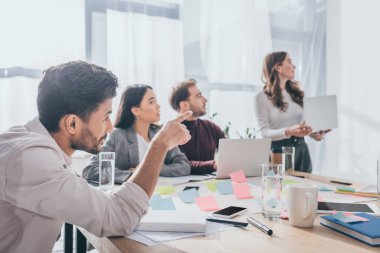 Seçici odak noktası karışık ırk kargaşası ustası ofisteki meslektaşlarını işaret ediyor. 