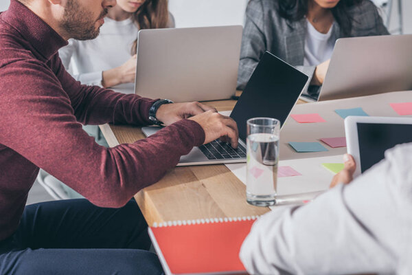 cropped view of scrum masters using laptops in office 