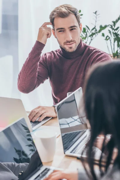 俊俏商人在手提电脑附近思考的选择性焦点 — 图库照片