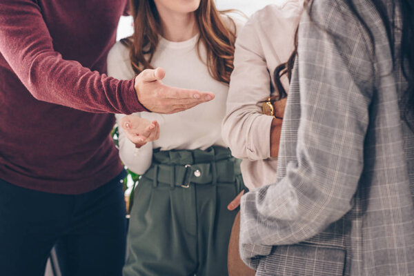 selective focus of coworkers posing while standing in office 