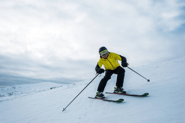 sportsman holding ski sticks while skiing on white snow