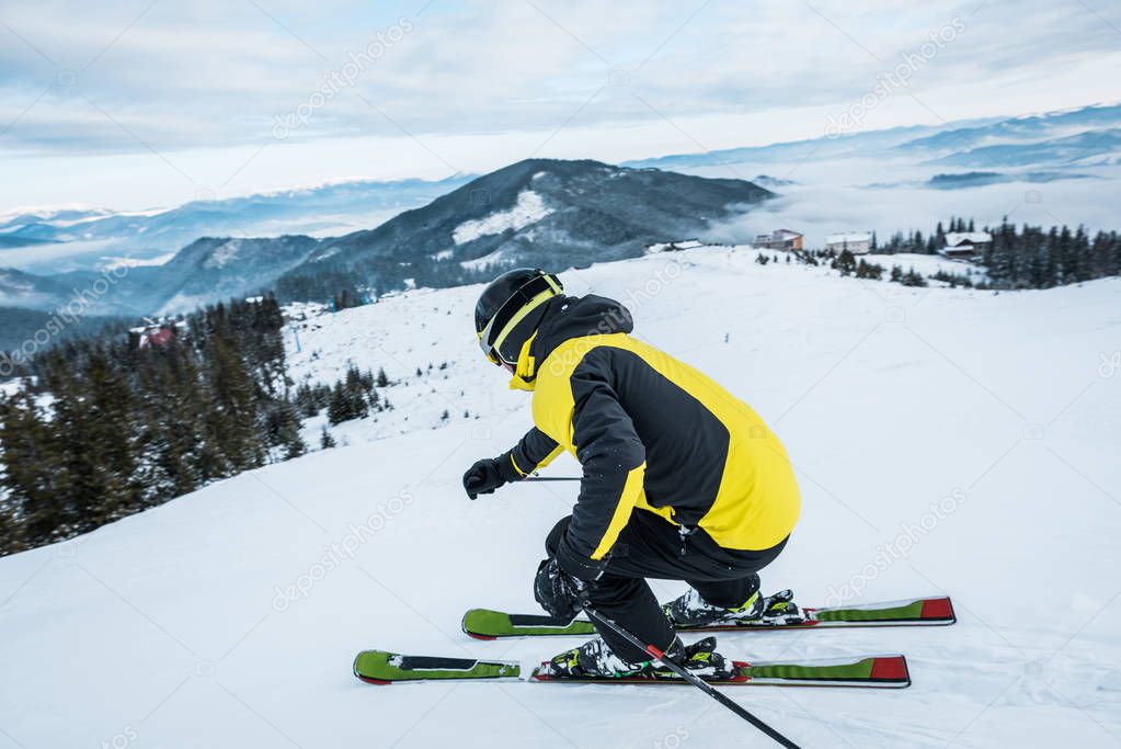 sportsman in helmet skiing in mountains