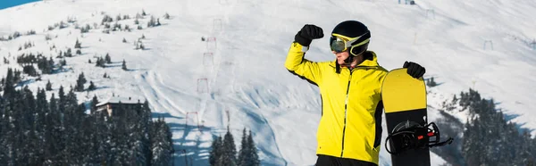 Panorámás kép snowboardos áll a hegyekben, és félrenéz — Stock Fotó