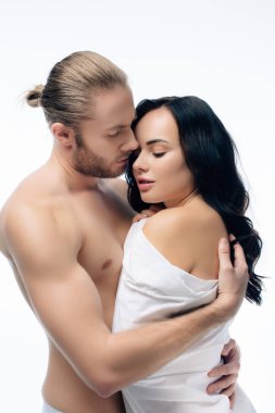 Tutkulu genç bir çift beyaz çarşaflar içinde sarılıyorlar.