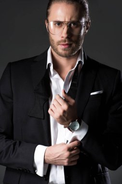 Takım elbiseli ve kravatlı kendine güvenen bir adam gri üzerine izole edilmiş.