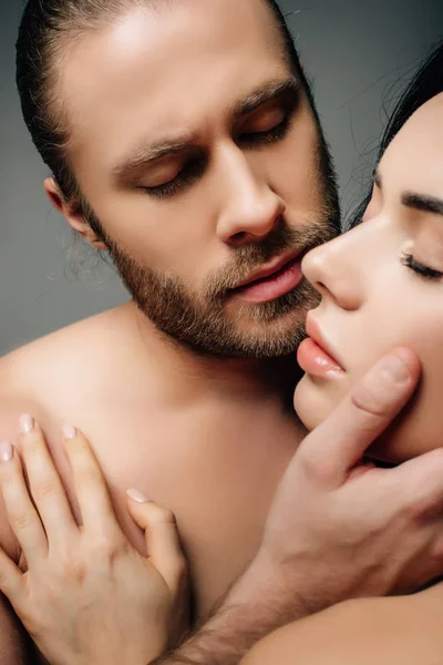 若い裸のカップルが抱き合ってキスをしますグレーで隔離され — ストック写真
