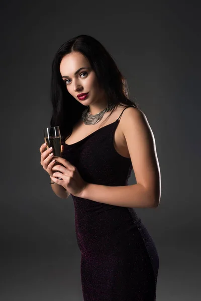 Atraktivní Dívka Černých Šatech Drží Sklenici Šampaňského Izolované Šedé — Stock fotografie