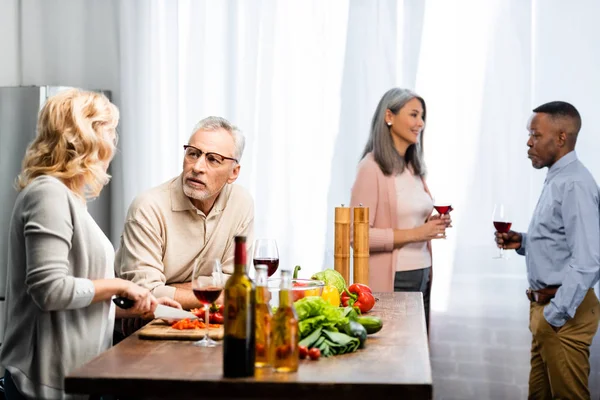 Selective Focus Woman Cutting Bell Pepper Talking Man Multicultural Friends — Stock Photo, Image