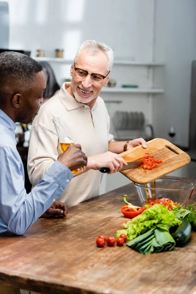 Hombre Afroamericano Sosteniendo Cerveza Amigo Agregando Tomates Cherry Ensalada — Foto de Stock