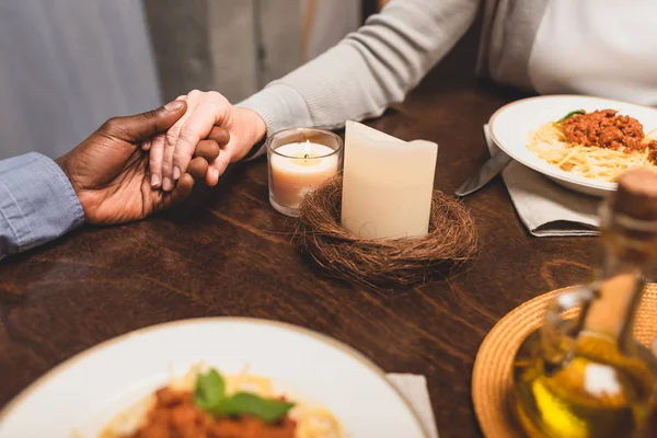アフリカ系アメリカ人の男性が友人の手を取り合い食事中に祈り — ストック写真