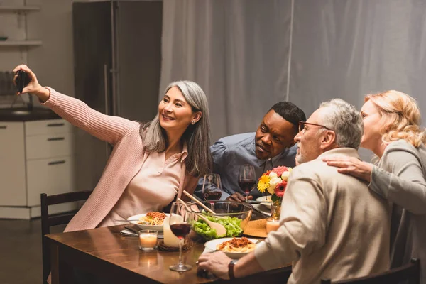 Amigos Multiculturais Sorridentes Tomando Selfie Com Smartphone Durante Jantar — Fotografia de Stock