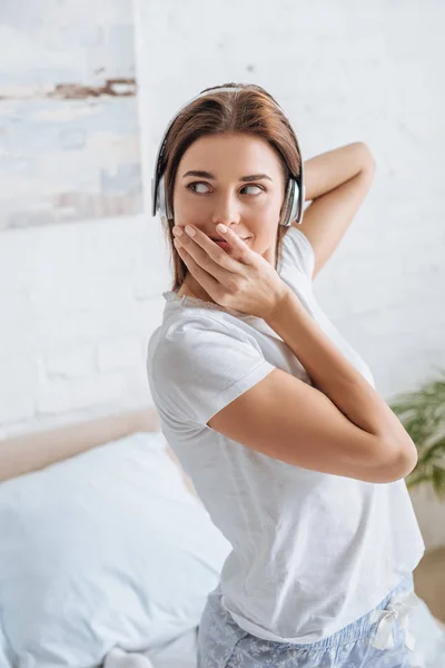 Young Woman Covering Mouth Listening Music Home — Stock Photo, Image
