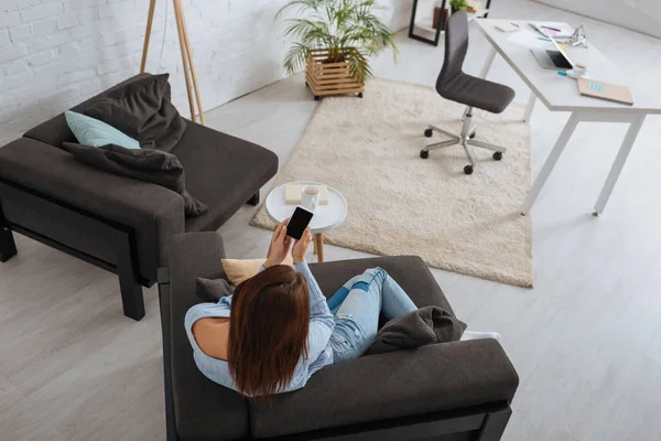 Achteraanzicht Van Jonge Vrouw Met Smartphone Met Blanco Scherm Thuis — Stockfoto