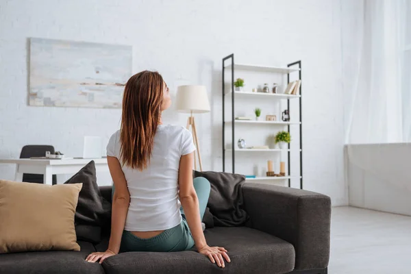 Verträumte Junge Frau Sitzt Auf Sofa Modernen Wohnzimmer — Stockfoto